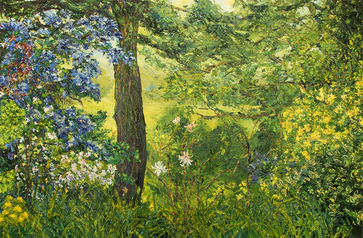 Close-crop of a Spring garden scene with a tree form to left, assorted branches, leaves and florals, especially leaning from the frame edges. Blue blossoming to the left dominates the image. Hazy land and organic forms discernible beyond the foreground botanicals.